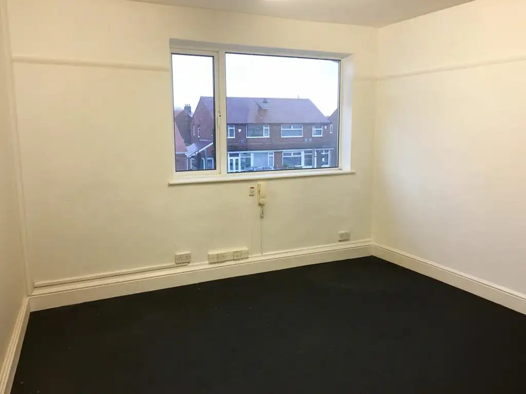 Office 2 interior at Gallery House, empty, with a wide front-facing window and the door entry handset on the wall